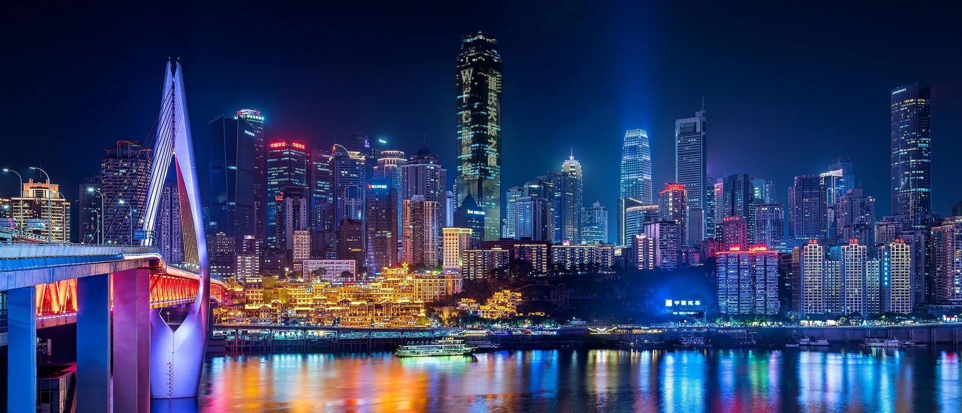 Chongqing's skyline and Hongyadong lit up at night beside the Qiansimen Bridge