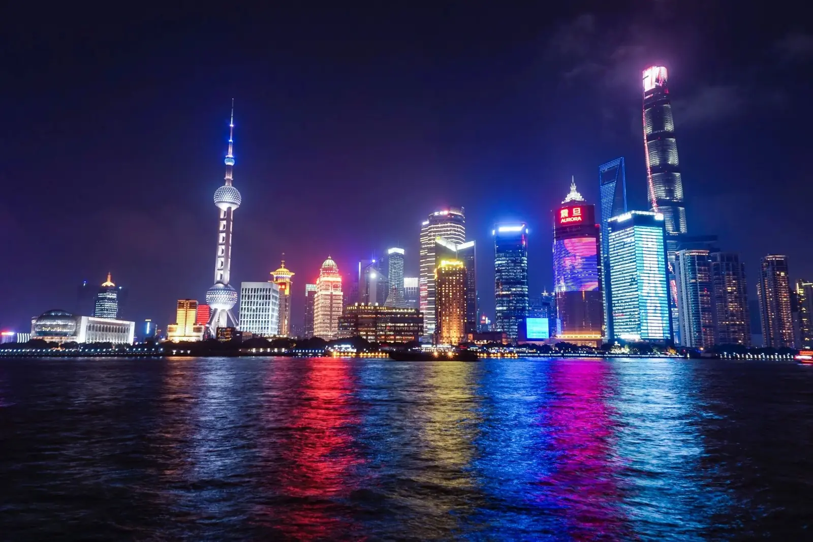 The Lujiazui skyline at night seen from the Bund — the Oriental Pearl Tower and Shanghai Tower across the Huangpu River