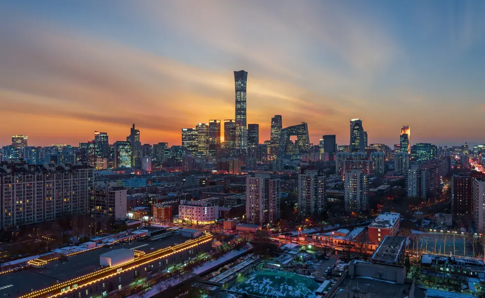 Beijing's skyline at dusk — the China Zun tower and the CCTV headquarters lit up in the CBD