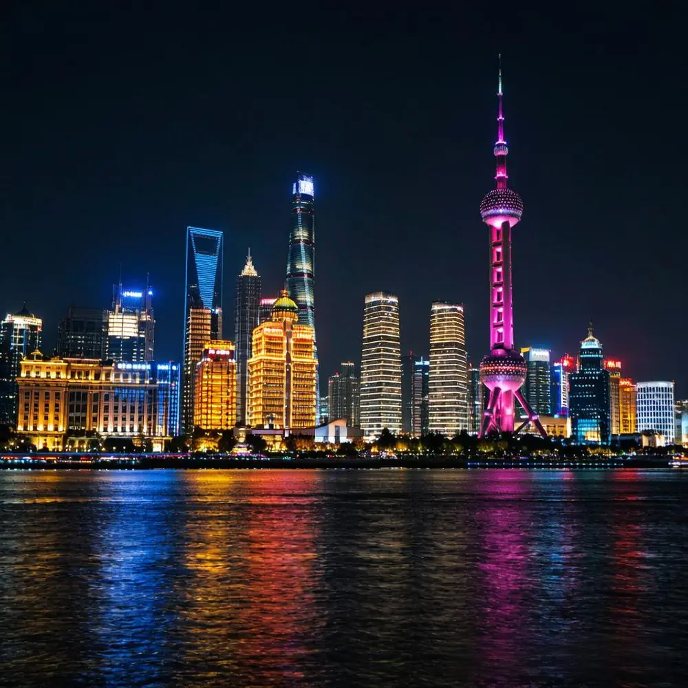 Shanghai skyline at night with the Oriental Pearl Tower lit up across the Huangpu River