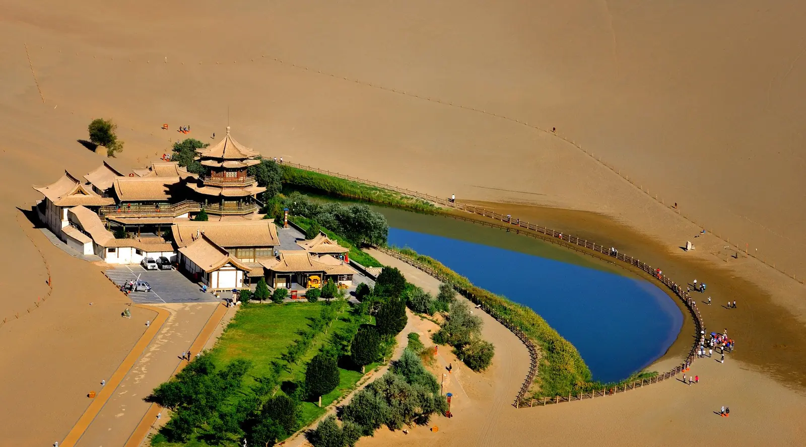 The giant sand dunes of Mingsha Shan curving around Crescent Lake near Dunhuang, Gansu