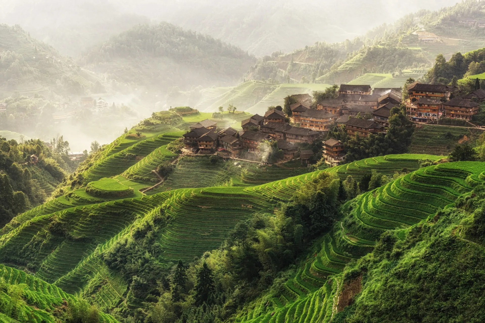 The green Longji rice terraces and a hillside village in the hills above Guilin
