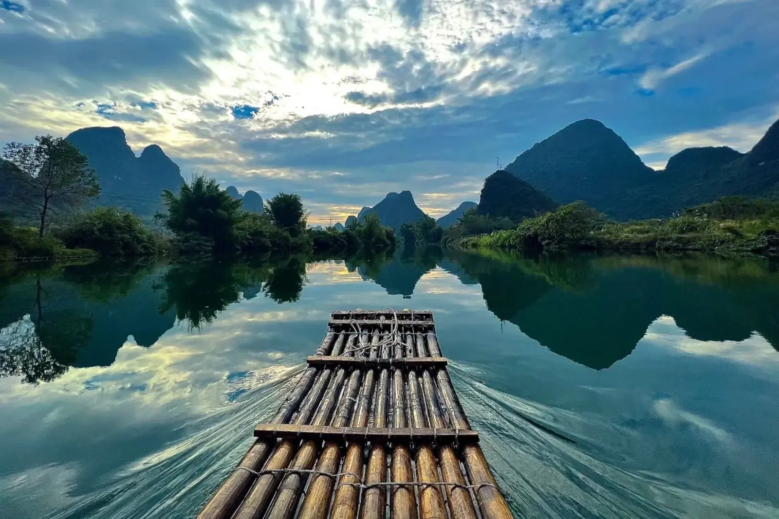 A bamboo raft on a calm river between karst mountains near Yangshuo
