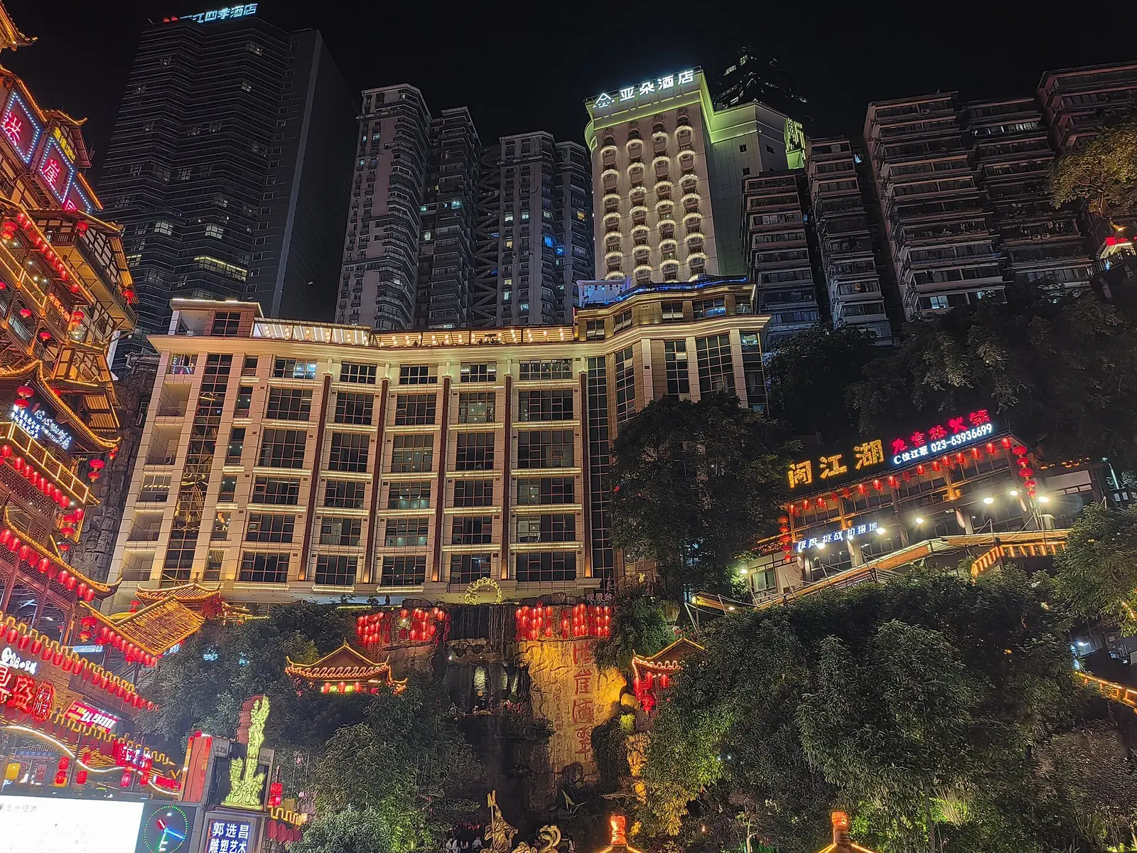 Restaurants, red lanterns and hotpot signs lit up at night along the Hongyadong food streets in Chongqing